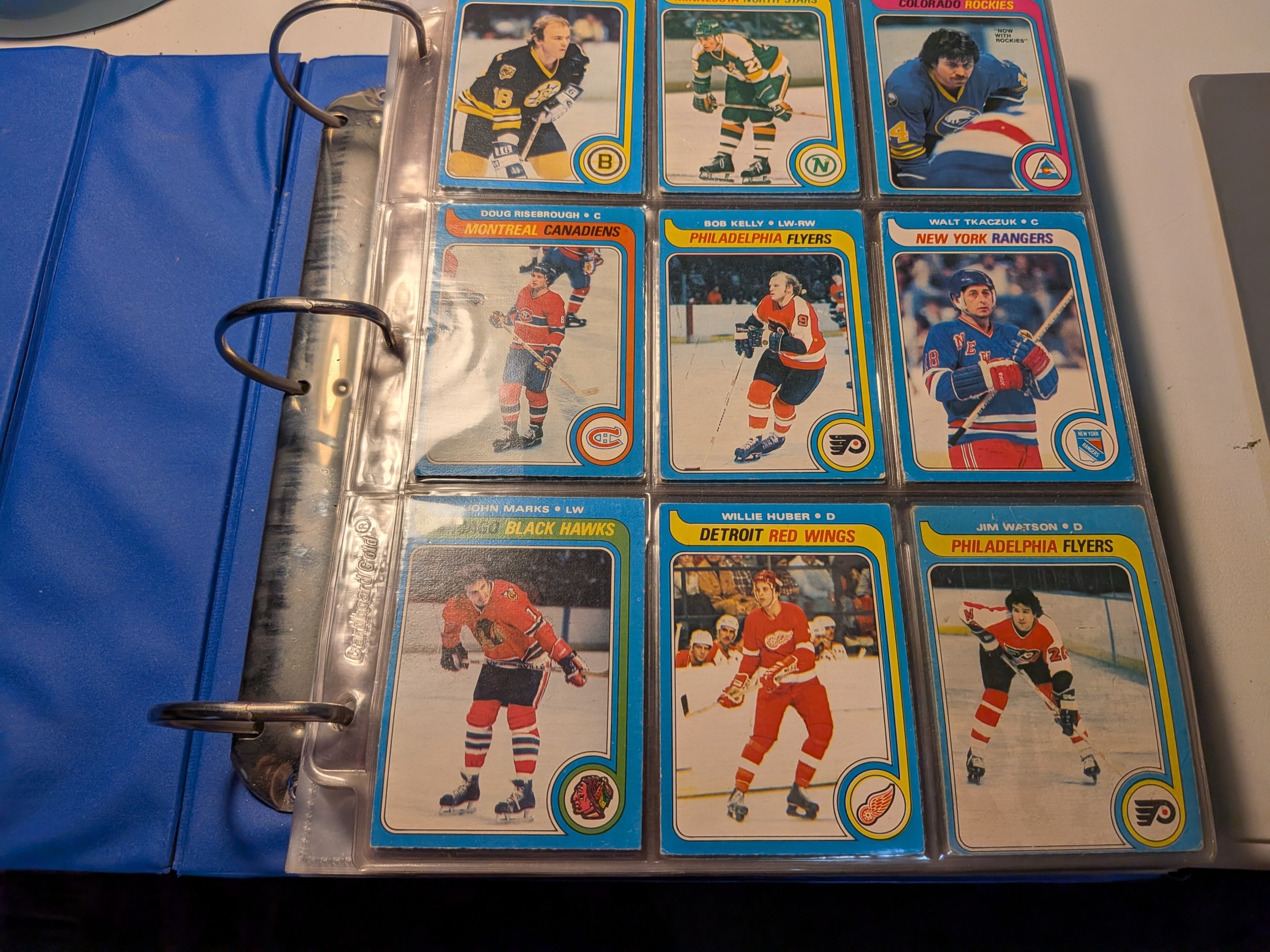 Multiple players visible: Doug Risebrough, Bob Kelly, Walt Tkaczuk, John Marks, Willie Huber, Jim Watson (plus 3 partially visible top row)
